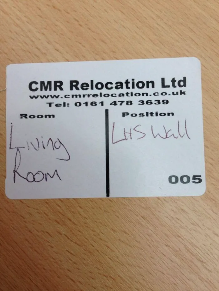 CMR Relocation label card marked living room, left-hand wall